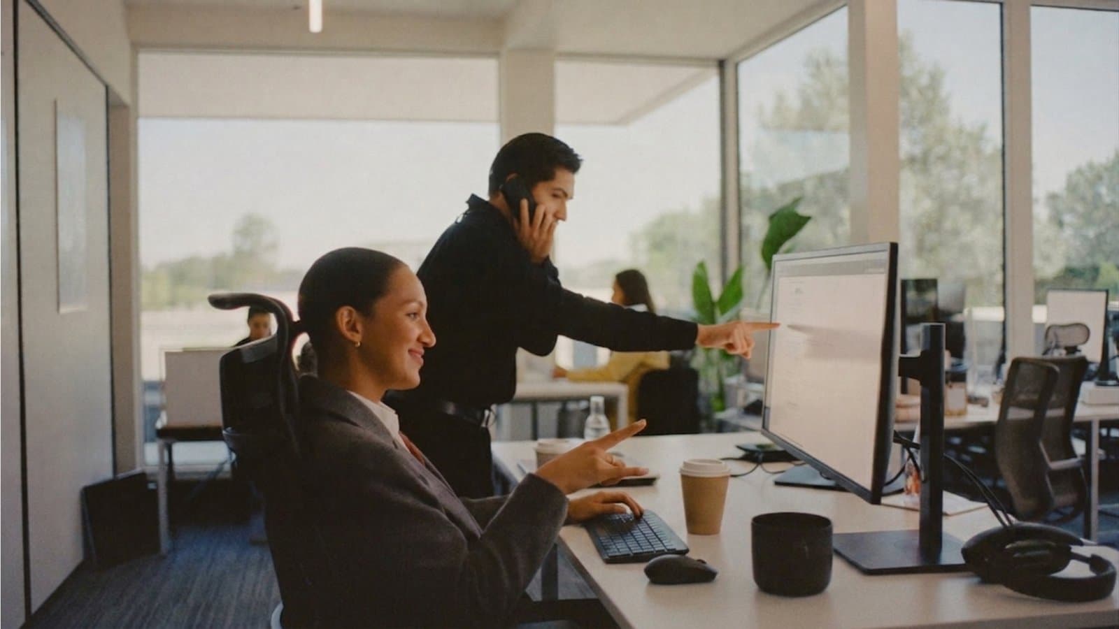 A real estate agent smiling on a call at a desk, the Seltis AI assistant open on the monitor
